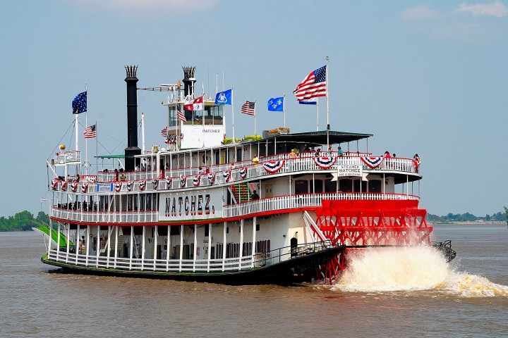 a large ship in the water with Delta Queen in the background